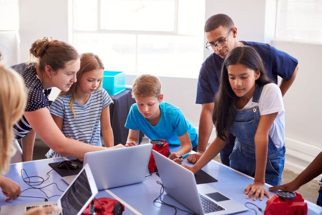 Foto de atividade escolar envolvendo programação, robótica e colaboração
