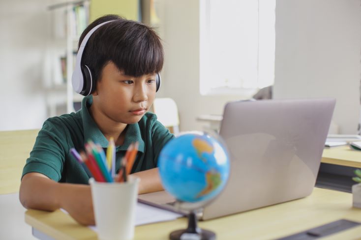 Conheça 8 novas metodologias de ensino para sua escola 3 Foto de garoto estudando na biblioteca em notebook (ensino híbrido)