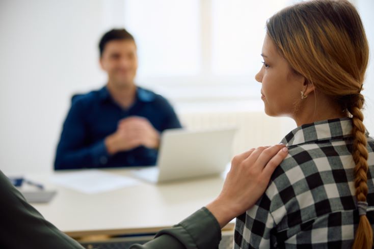 Dificuldade de aprendizagem: o que é e como identificar? 1 Foto de aluna com dificuldade de aprendizagem, acompanhada de sua mãe, em reunião com coordenador pedagógico na escola