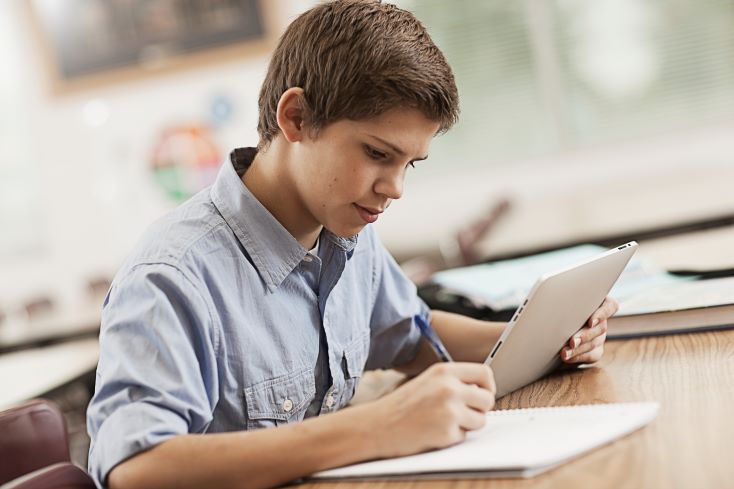 Personalização do ensino: o que é, qual a importância e como a tecnologia pode ajudar 1 Foto de garoto estudando em plataforma de aprendizagem adaptativa
