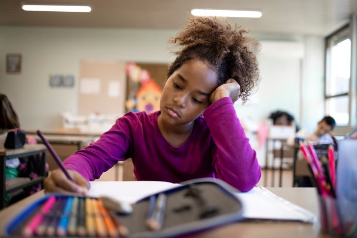 Recomposição de aprendizagem: como reduzir as perdas da pandemia 1 Foto de menina estudante com dificuldade em matemática.