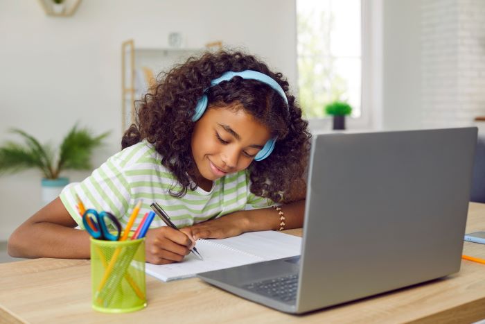 Metodologias ativas de aprendizagem: 12 tipos e como adotá-las 2 Foto de estudante feliz estudando em plataforma digital.