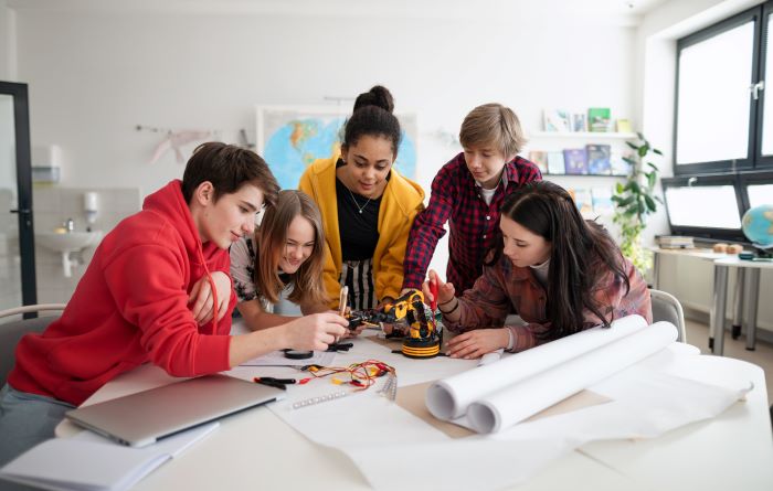 Grupo de alunos do Ensino Médio realizando projeto escolar, de acordo com metodologias ativas de aprendizagem.