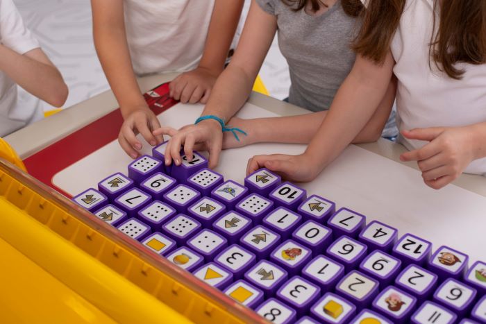 Atendimento Educacional Especializado (AEE): o que é e como melhorá-lo? 3 Foto de estudantes aprendendo sobre letramento com Mesa Educacional.