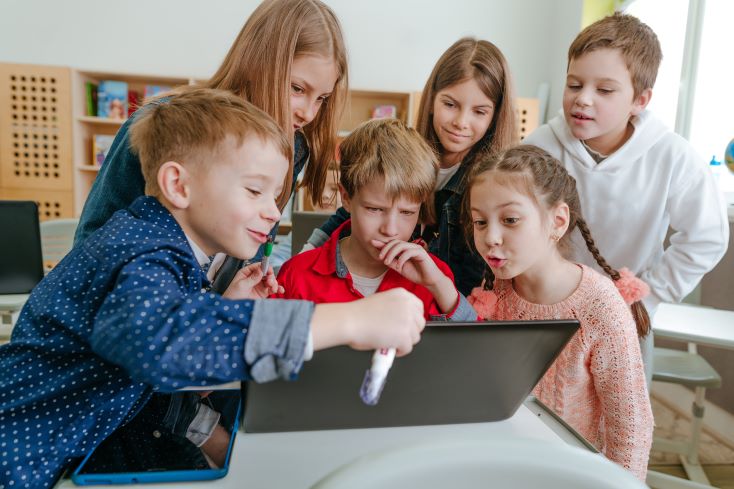 Educação 5.0: o que é e como se adequar à nova fase 1 Foto de estudantes interagindo com notebook em sala de aula.