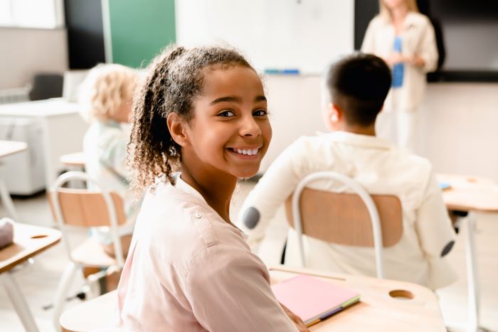 4 pilares da educação: quais são e como aplicar 1 : Foto de menina em sala de aula