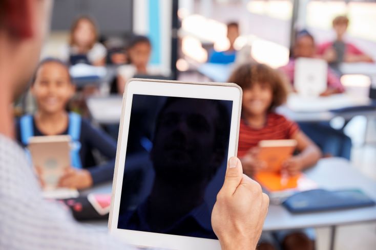 Aprendizagem adaptativa: conheça as vantagens da tendência 1 Foto de professor segurando tablet em sala de aula