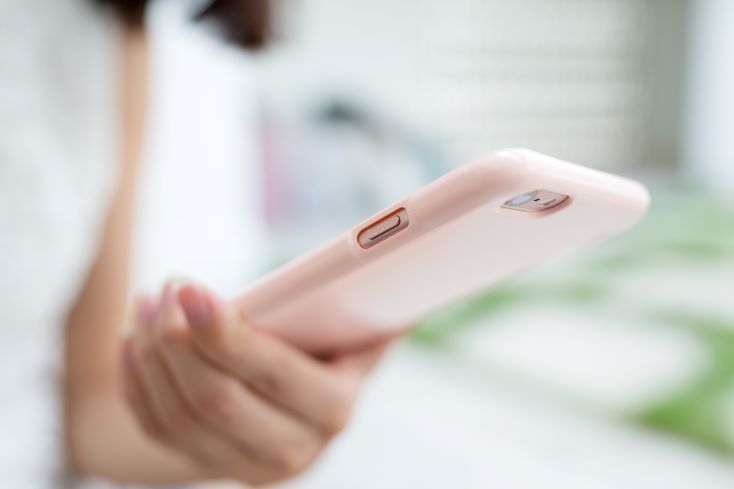 11 dicas para uma campanha de matrículas de sucesso 4 Foto de mulher utilizando celular para acessar mídia social, que é mais um canal de comunicação para a campanha de matrículas