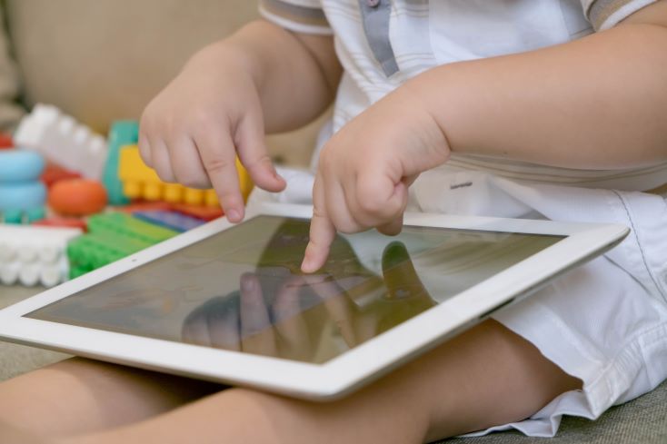 Tecnologia na Educação Infantil: importância e como utilizar 1 Foto de aluno da Educação Infantil explorando livro digital