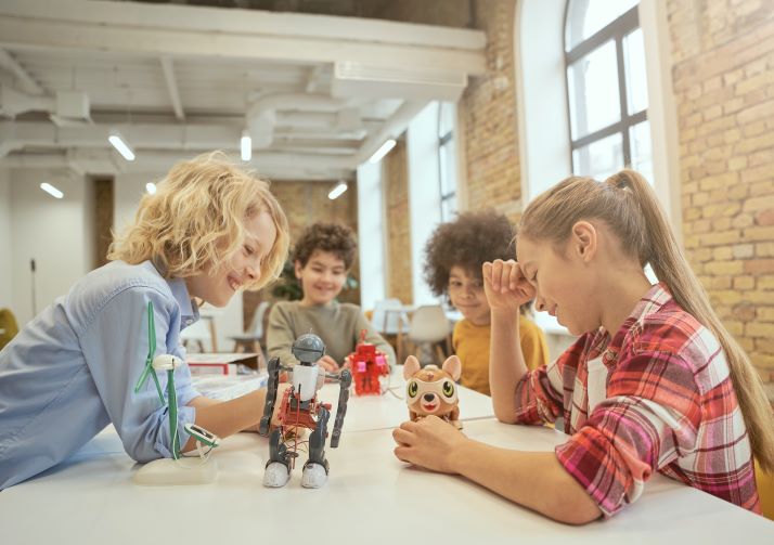 Aprendizagem ativa: o que é e quais são as suas vantagens? 1 Foto de estudantes brincando com robôs e brinquedos em sala de aula
