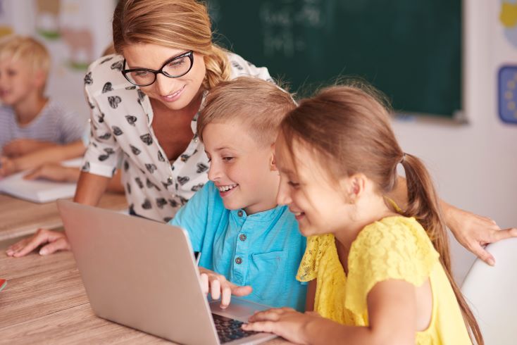 10 recursos didáticos que não podem faltar na sua escola 1 Foto de professora orientando alunos no uso de recursos didáticos online