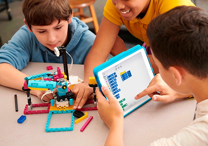 Aprendizagem significativa: saiba como promover na sua escola 2 Estudantes do Ensino Fundamental programando robô de LEGO Education, o que favorece a aprendizagem significativa.