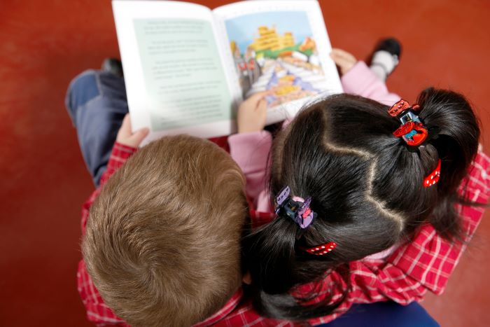 Alfabetização e letramento: diferentes, mas complementares 2 Foto de crianças lendo um livro juntas