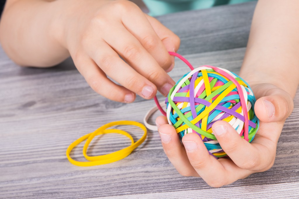 Atividades lúdicas para educação infantil: 12 ideias práticas para sala de aula 9 Foto de criança manipulando elásticos