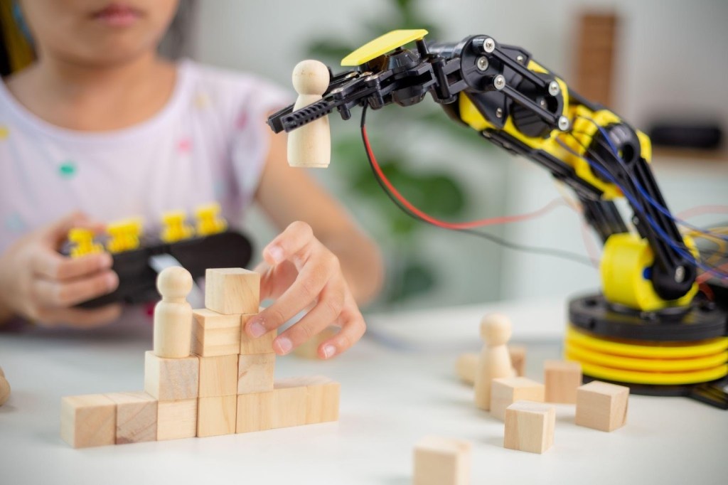 Como a tecnologia pode apoiar crianças autistas no ambiente escolar? 1 Foto de aula de robótica e criança ao fundo