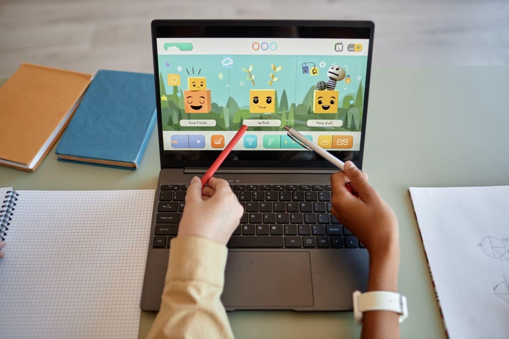 Maratonas de Matemática e Língua Portuguesa: Ideias para engajar alunos e elevar o desempenho 1 Foto de duas crianças usando a gamificação e caderno de matemática