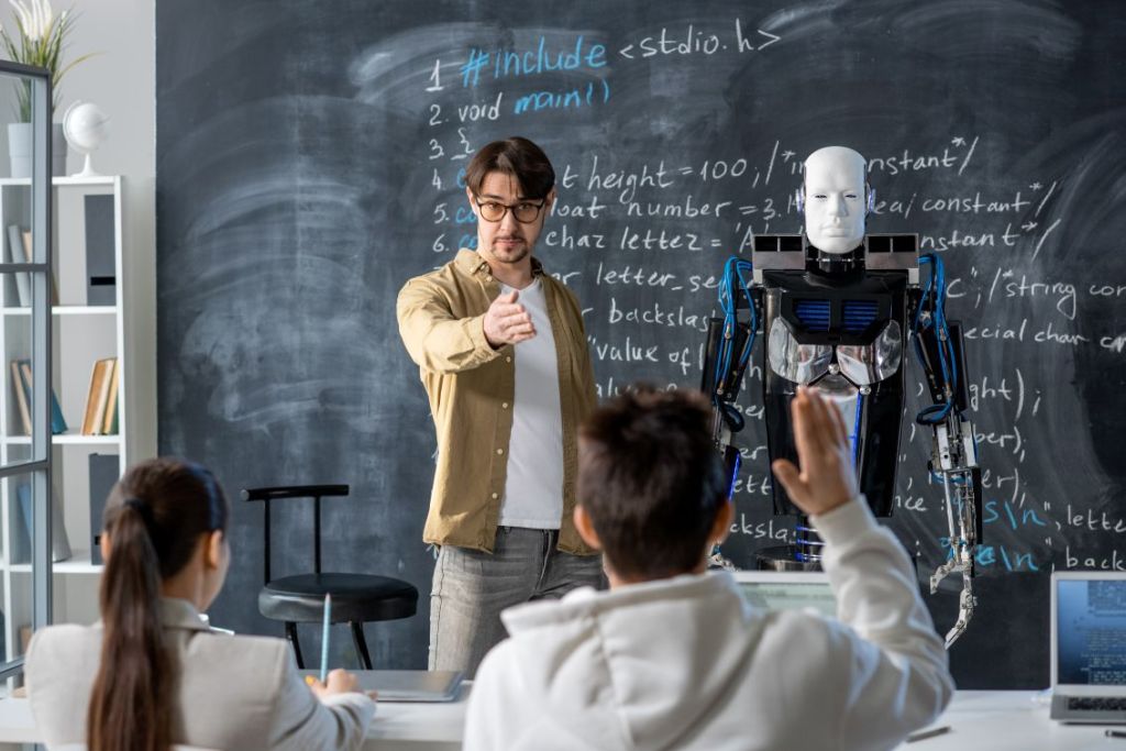 Foto de professor e robô dividindo a sala de aula