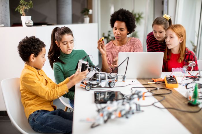 O papel do professor em tempos de inteligência artificial 2 Foto de professor e alunos em aula com uso de tecnologia