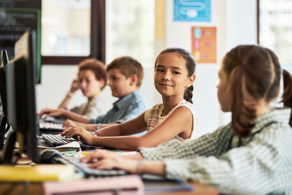 Foto de alunos usando tecnologia em sala de aula