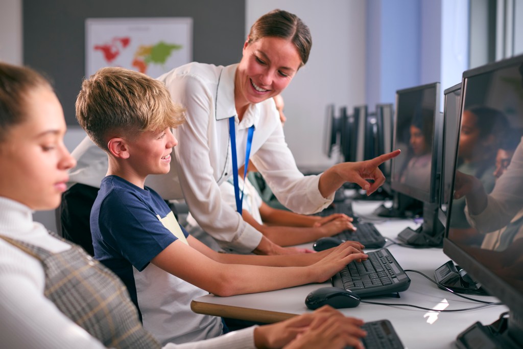 IDEB 2025: evolução de 5 municípios que já utilizaram o Aprimora 1 Foto de alunos usando a tecnologia em sala de aula com mediação do professor