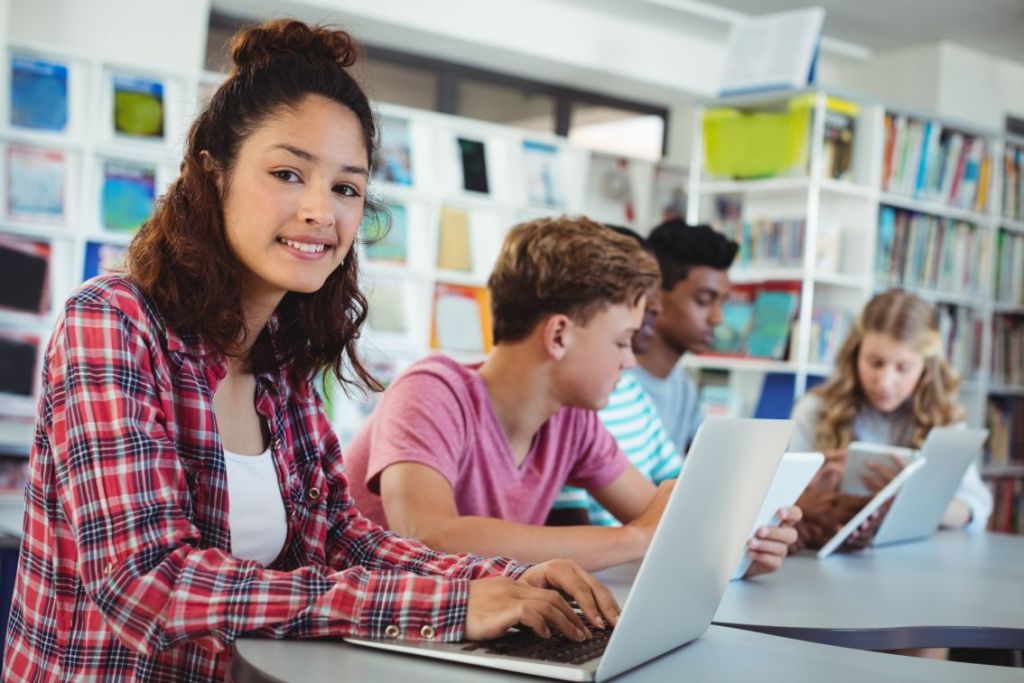 Foto de alunos usando a tecnologia em sala de aula